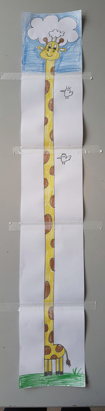 A very tall, narrow marker drawing on three taped sheets of paper: a small giraffe at the bottom whose spotted neck stretches all the way to the top, where it bites a white cloud.