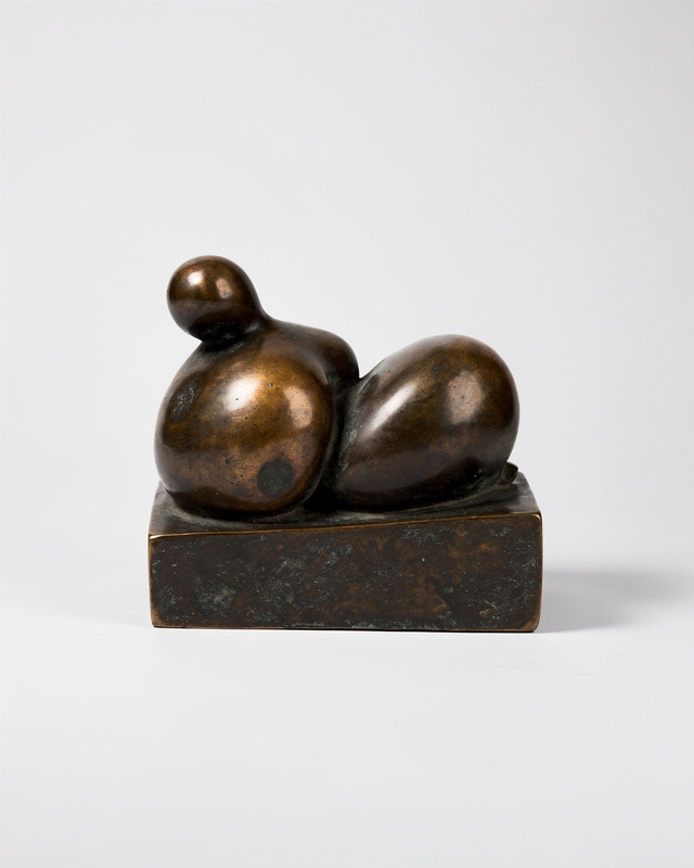 An abstract bronze sculpture made of smooth simplified rounded masses that suggest a person resting on a low block, no anatomical detail, like a weathered stone worn smooth, dark patina with warm highlights.