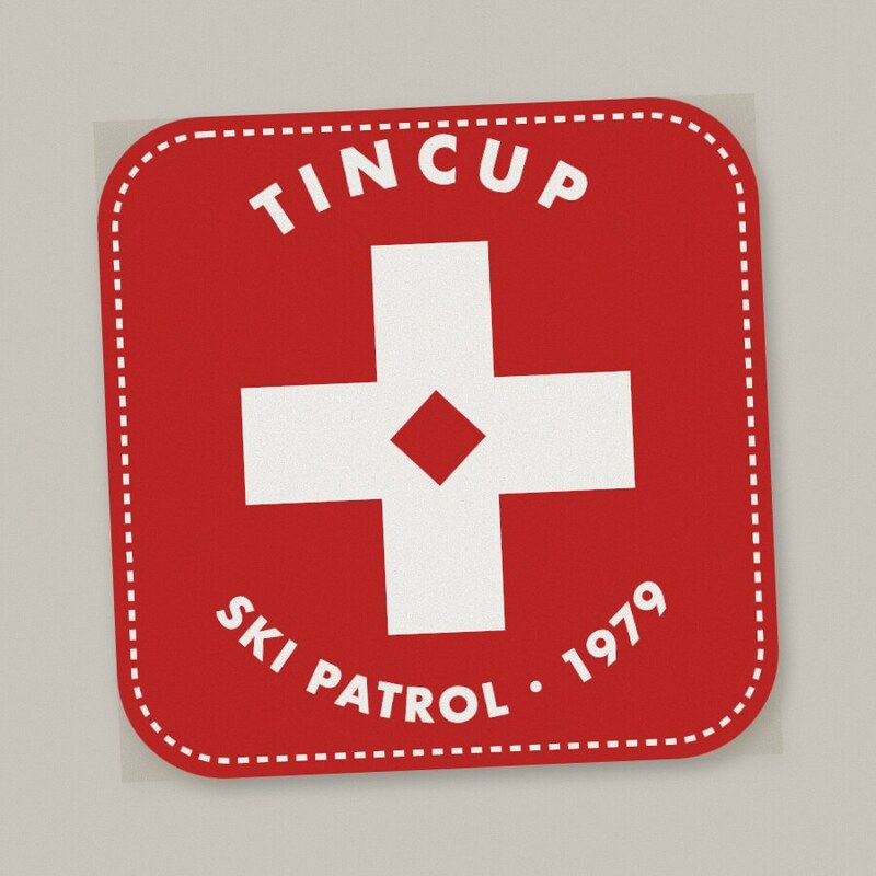 Square red patch with a white cross and stitched border, lettered Tincup Ski Patrol 1979.