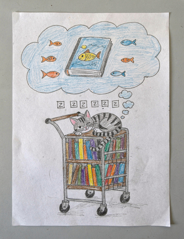 Marker drawing of a gray striped cat asleep on a library book cart, with a dream bubble above showing a book with a fish on its cover surrounded by swimming fish.