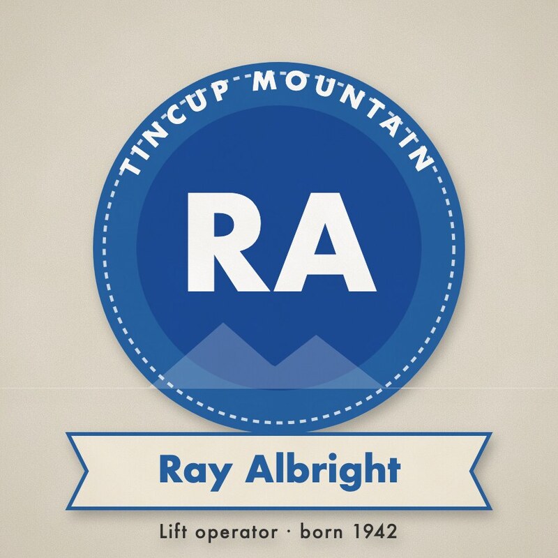 Blue roundel badge with the initials RA and a ribbon reading Ray Albright, Lift operator, born 1942.