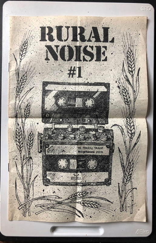 Zine cover: Rural Noise number 1, with a drawing of a cassette tape above a tape deck, framed by stalks of wheat.