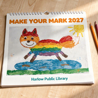 Spiral-bound wall calendar on a wooden table. The cover reads Make Your Mark 2027 above the Rainbow Fox painting, with Harlow Public Library below.